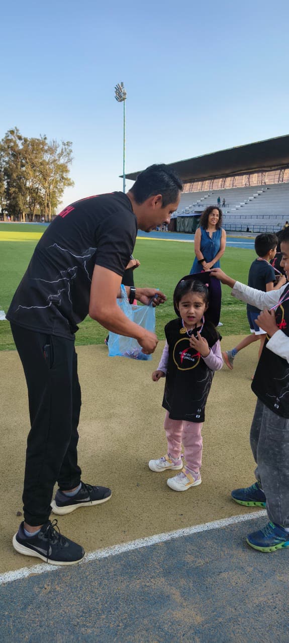 Entrenador colocando la medalla a una alumna